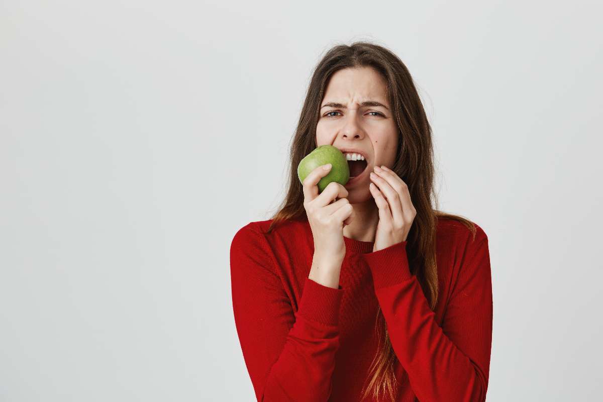 A girl facing difficulty in chewing food because of tooth cavities.