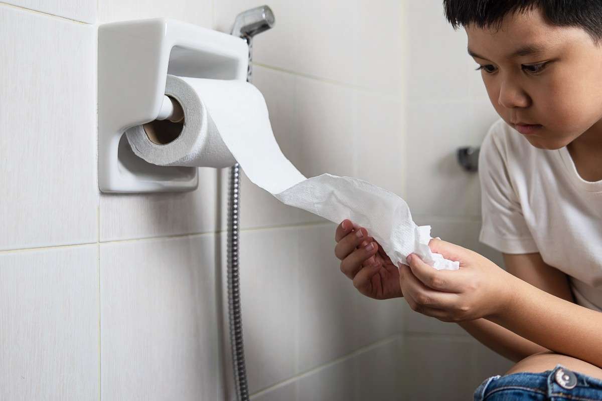 A young boy holding tissue paper while suffering from Diarrhea