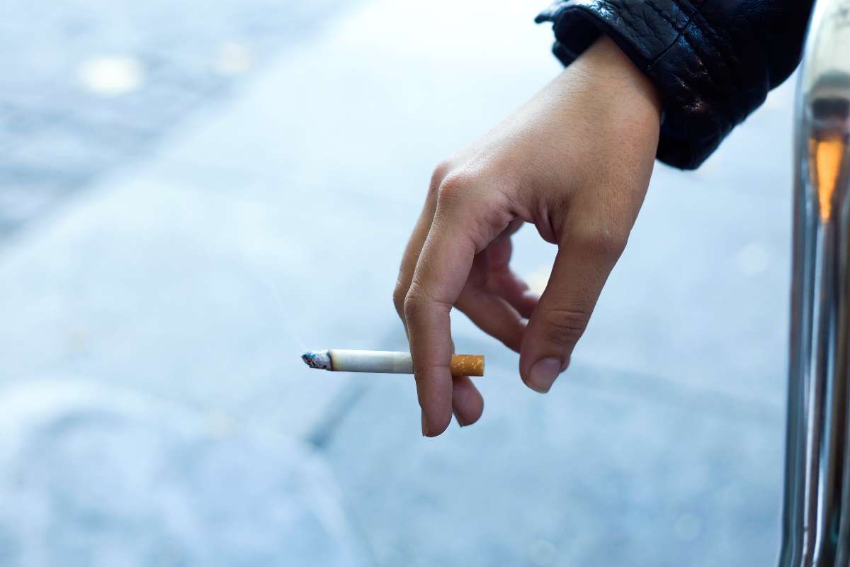 A girl holding a hand in a cigarette.