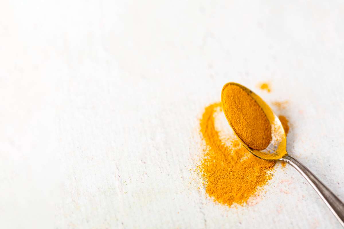 Turmeric in a spoon for turmeric paste that works amazing as a tooth cavities home remedy.